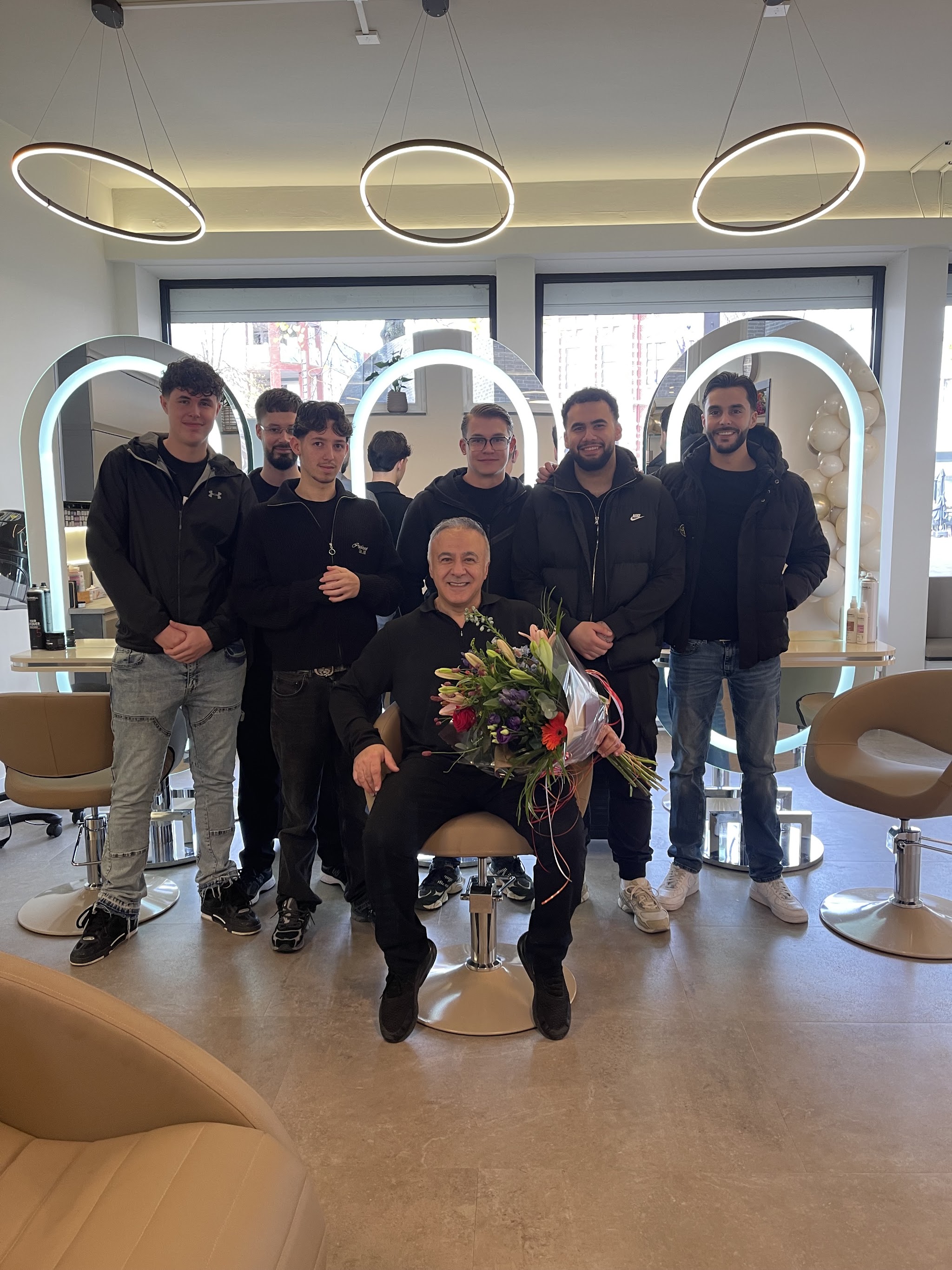 Het team van Maxim Hair in de nieuwe salon aan de Markt, met een bos bloemen voor de opening