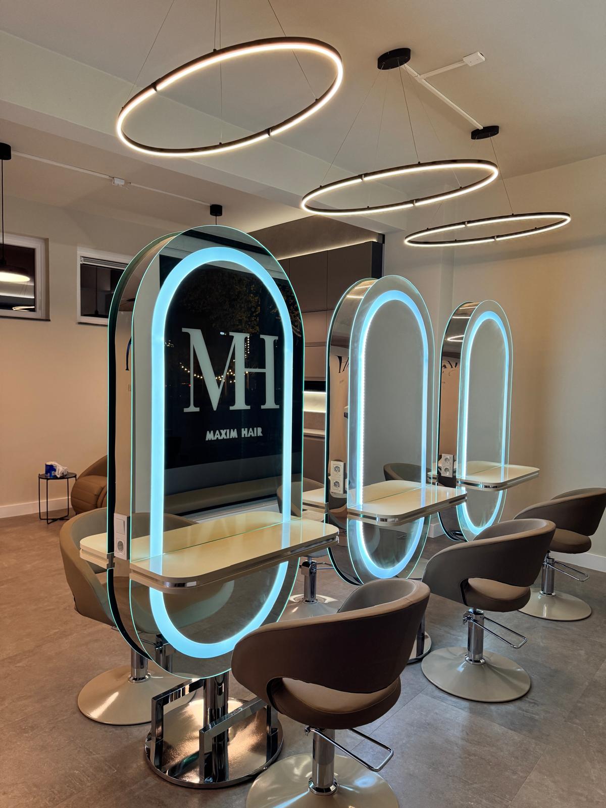 De nieuwe salon van Maxim Hair aan de Markt: drie boogvormige spiegels met LED-ringverlichting en taupe stoelen